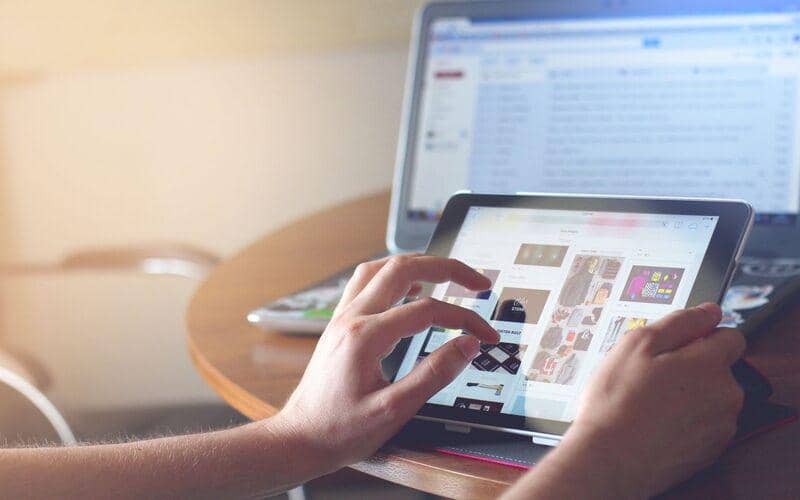ilustrasi seseorang menggunakan tablet dan laptop