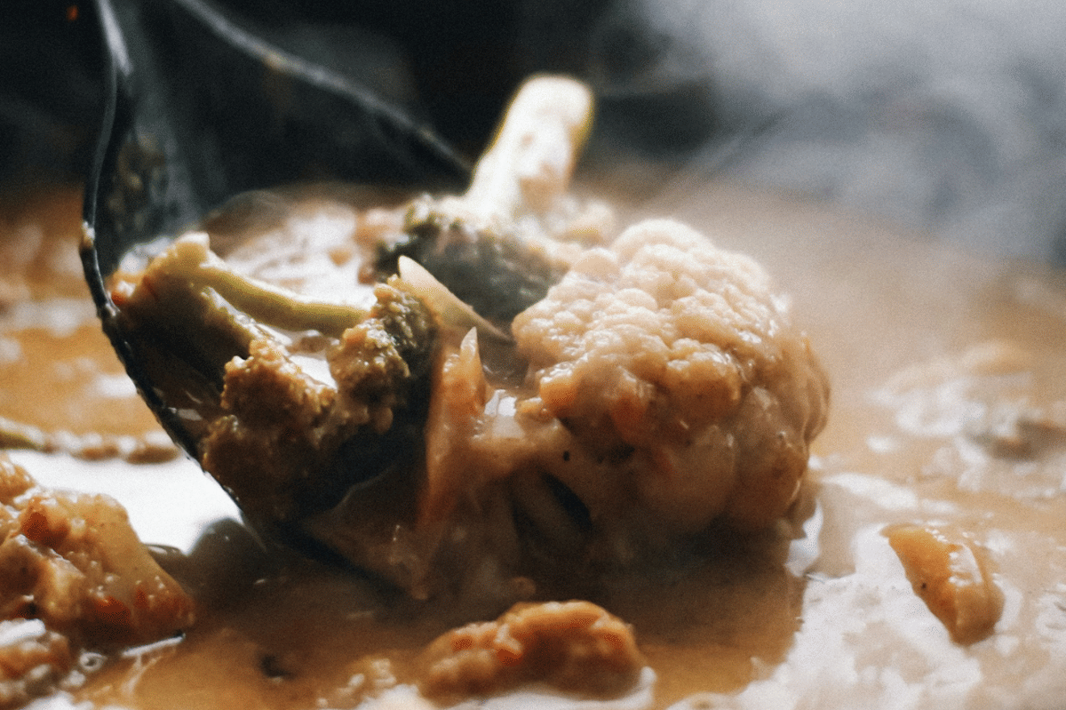 Ilustrasi proses membuat doenjang jjigae dengan bahan-bahan yang disiapkan untuk dimasak di dalam panci.