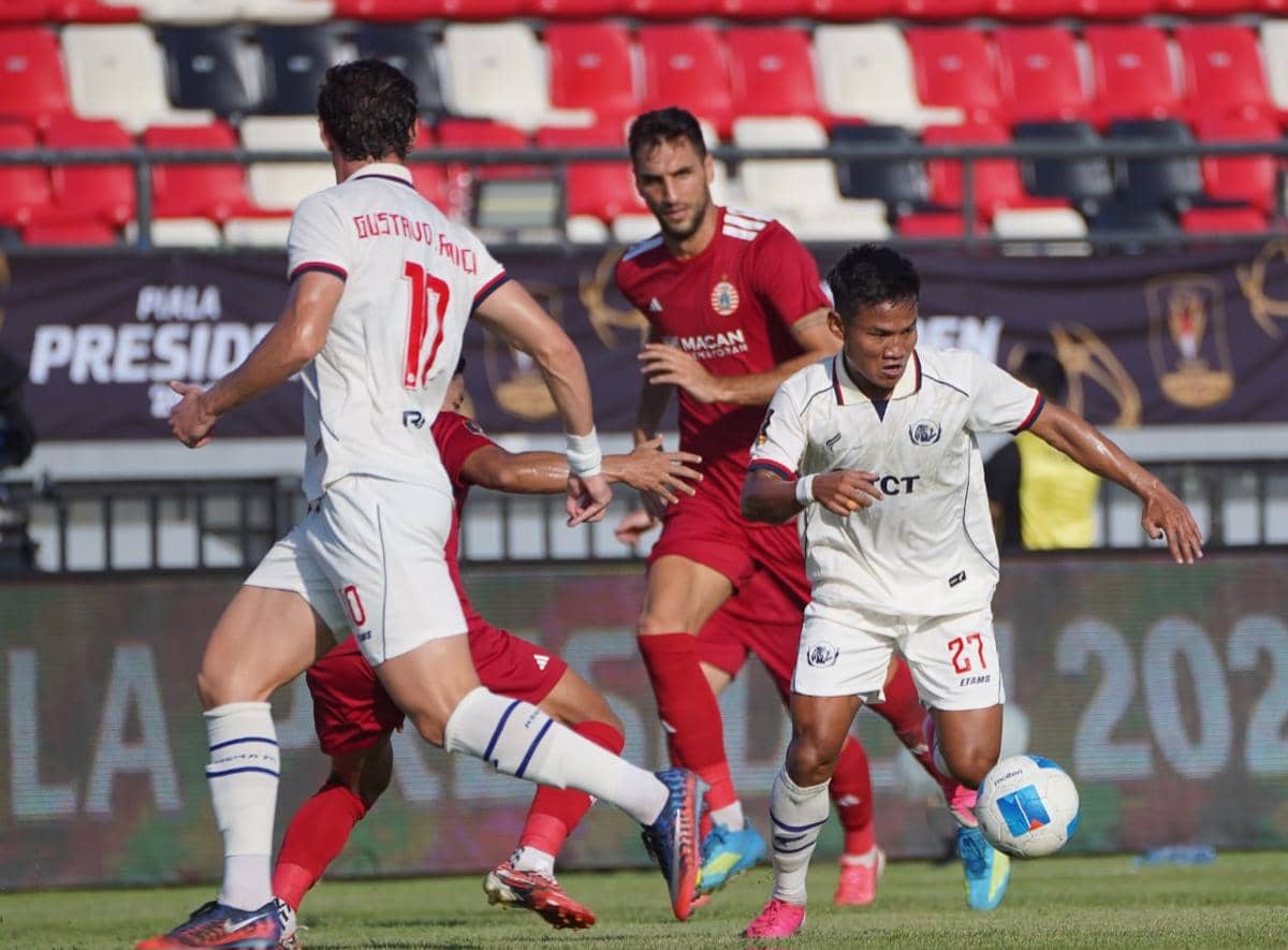 Para pemain Arema FC dan Persija bertanding dalam laga Piala Presiden 2026 di lapangan sepak bola berumput hijau.
