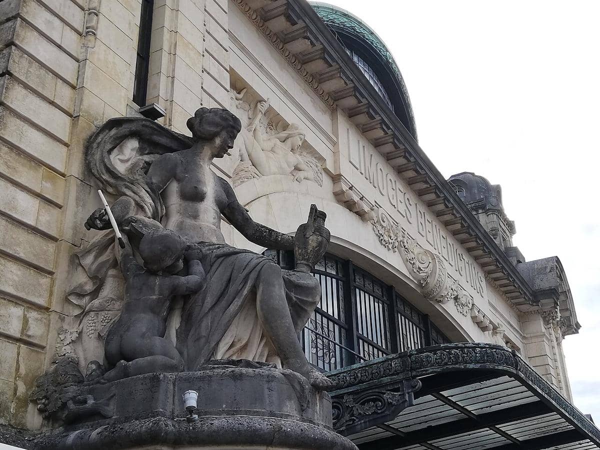 Patung batu kapur yang membingkai kanopi pintu masuk utama Stasiun Limoges-Bénédictins.
