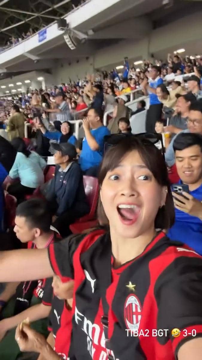 Seorang artis mengenakan jersey AC Milan saat menjadi suporter dalam pertandingan di Stadion GBK, Jakarta.
