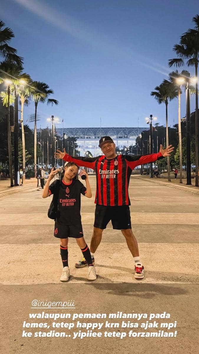 Seorang artis mengenakan atribut AC Milan berada di kawasan GBK saat mendukung klub sepak bola Italia tersebut.
