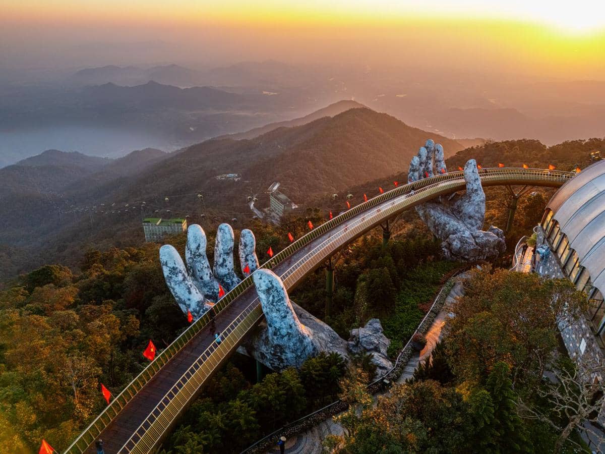 Jembatan Emas di Da Nang membentang di pegunungan, ditopang dua tangan raksasa bertekstur batu di tengah kabut.