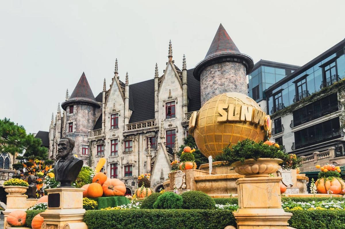 Pemandangan kompleks Sun World di Da Nang dengan bangunan bergaya Eropa dan pegunungan yang diselimuti kabut.