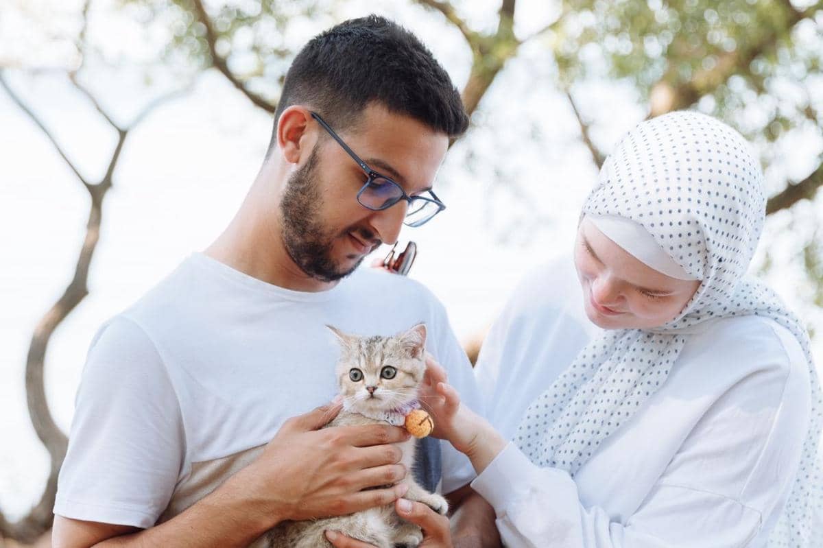 Ilustrasi seseorang bersama kucing peliharaan yang menggambarkan cat person sebagai green flag dalam dating.
