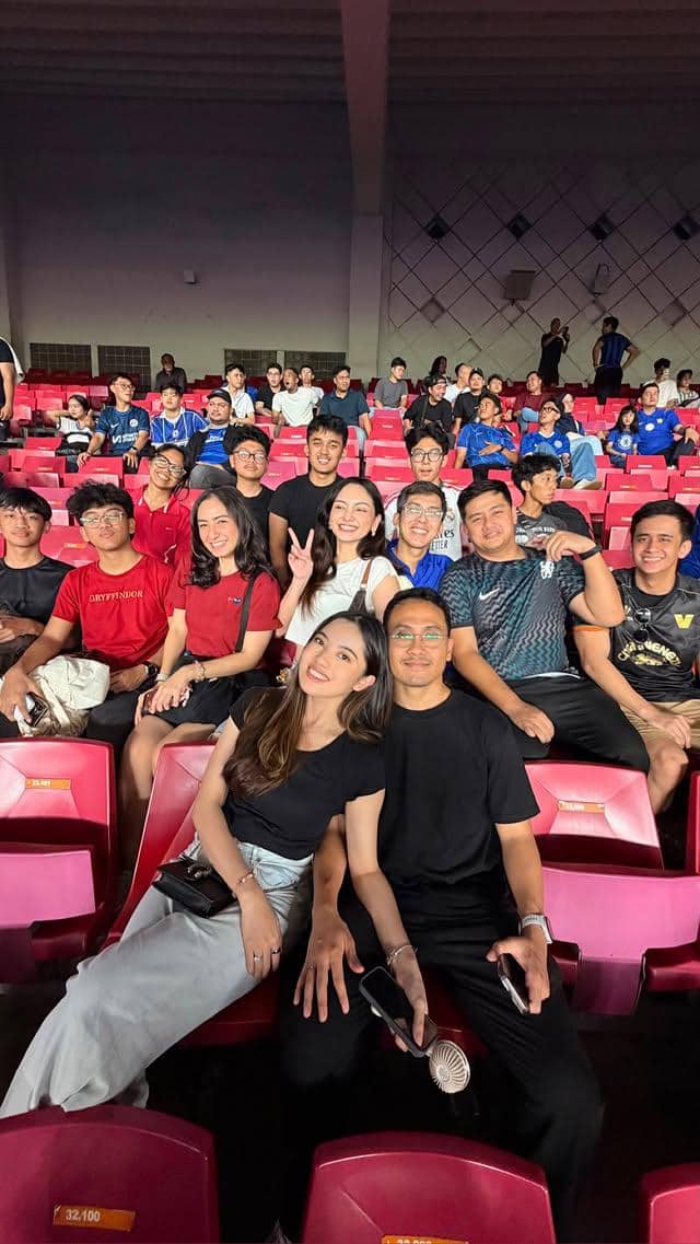 Seorang artis menyaksikan pertandingan Chelsea di Stadion Utama Gelora Bung Karno, Jakarta, sambil berpose untuk kamera.