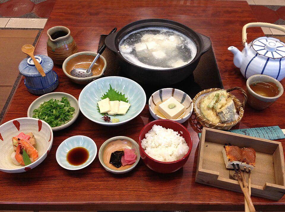 Satu set yudofu khas Kyoto berisi tahu rebus dalam kuah, disajikan bersama nasi, lauk pendamping, dan saus celup.