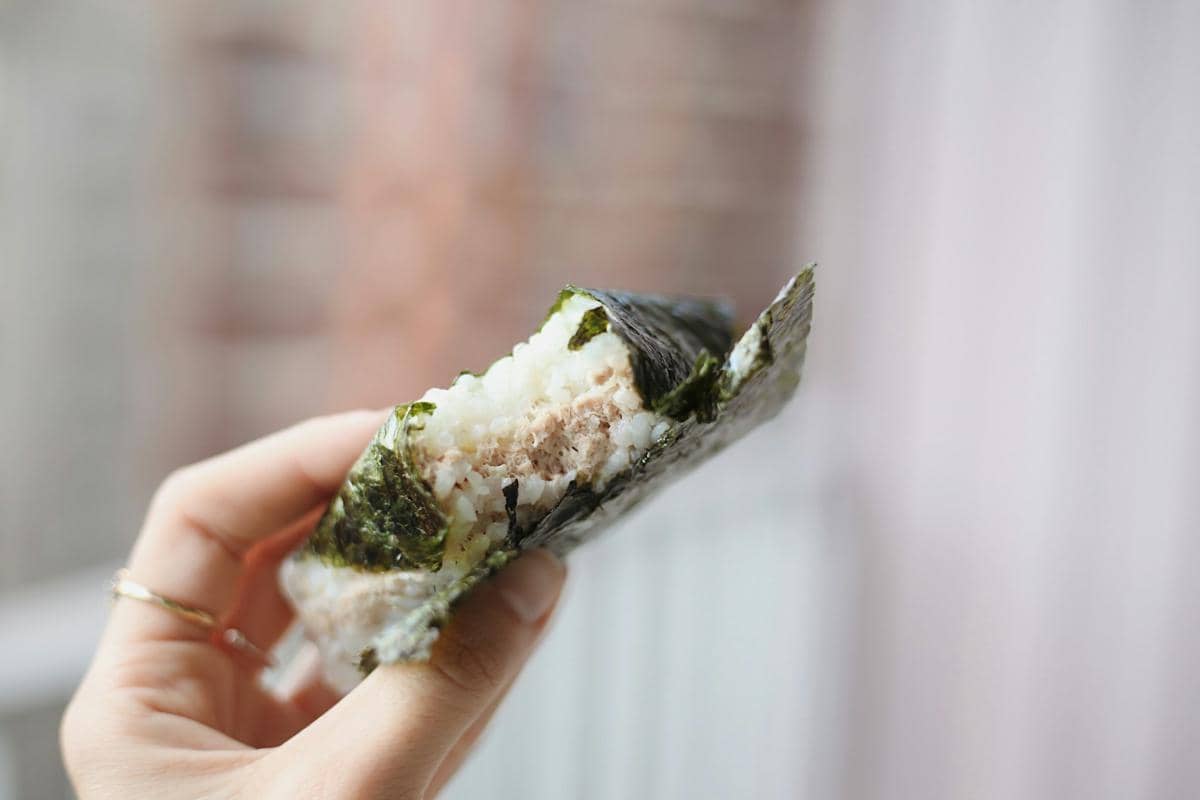 Ilustrasi onigiri, nasi kepal Jepang berbentuk segitiga dengan lembaran nori, karya Samia Liamani di Unsplash.