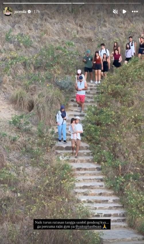Jessica Mila berpose di puncak Pulau Padar dengan panorama perbukitan dan laut biru di belakangnya saat berlibur.