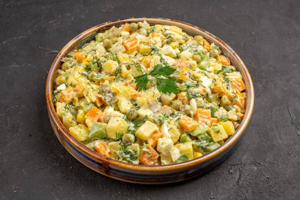 Semangkuk salad kimpul dengan sayuran segar, tomat ceri, dan saus, disajikan sebagai ilustrasi makanan sehat.