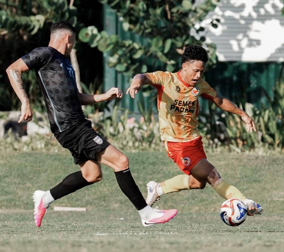 Para pemain Semen Padang FC dan Borneo FC bertanding dalam laga uji coba sepak bola di sebuah lapangan hijau.