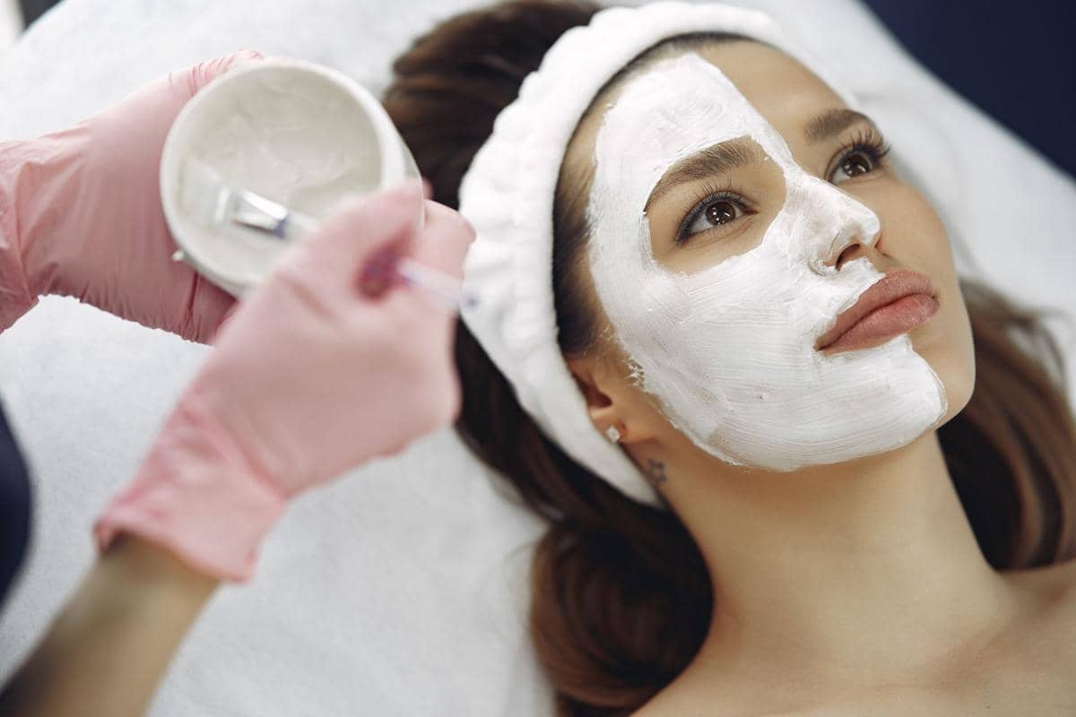 seorang wanita mengoleskan masker di wajah