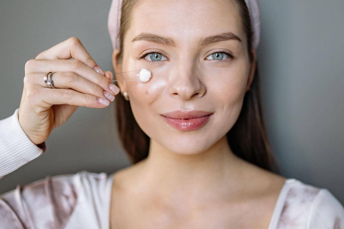 seorang wanita menggunakan moisturizer