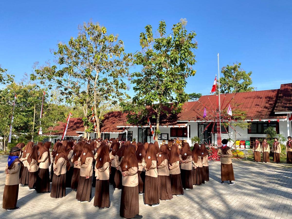 Anggota Pramuka mengikuti kegiatan atau upacara di lapangan.