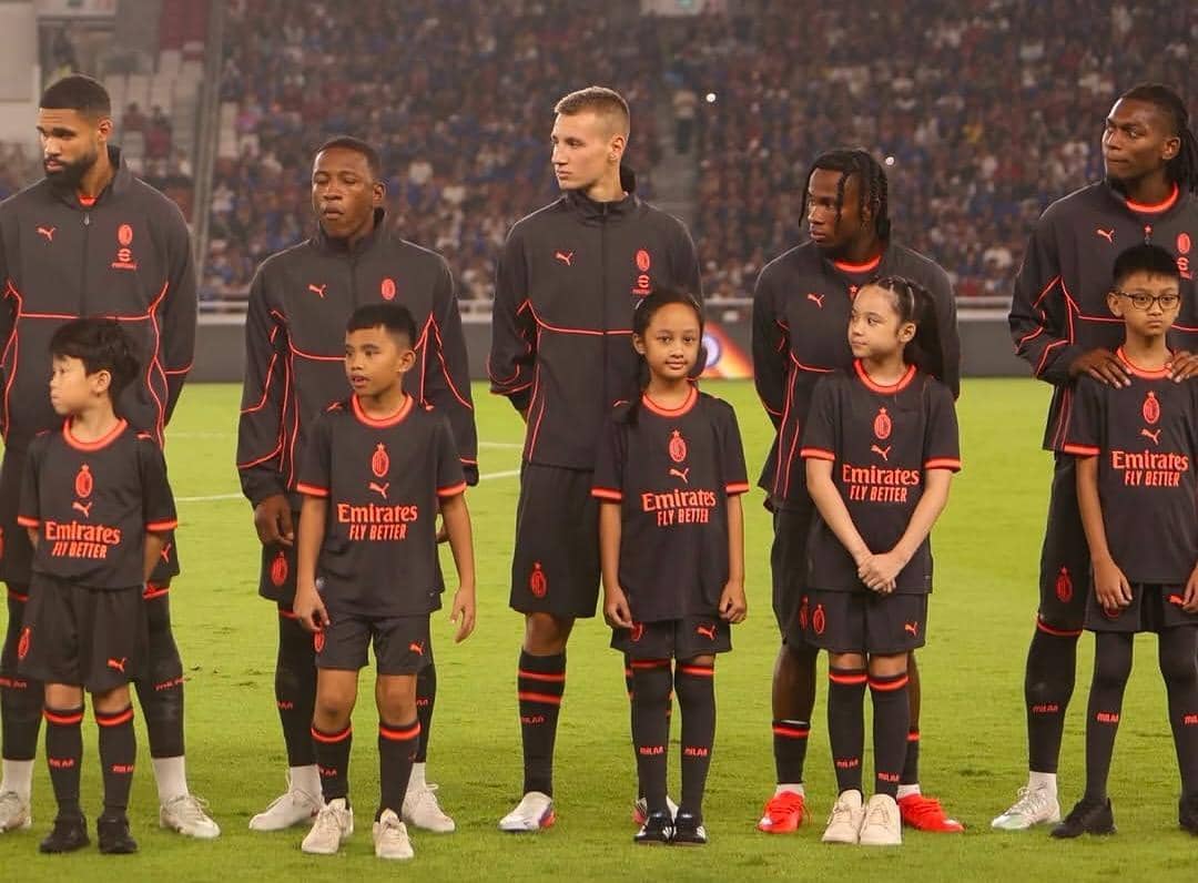 Gempi berpose sebagai maskot pemain saat menyaksikan laga sepak bola AC Milan melawan Chelsea di stadion.