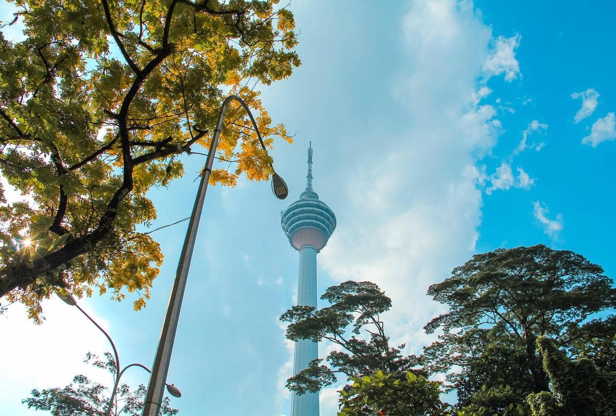 Menara Kuala Lumpur menjulang tinggi dengan kubah observasi di puncaknya, terlihat dari sudut pandang bawah.