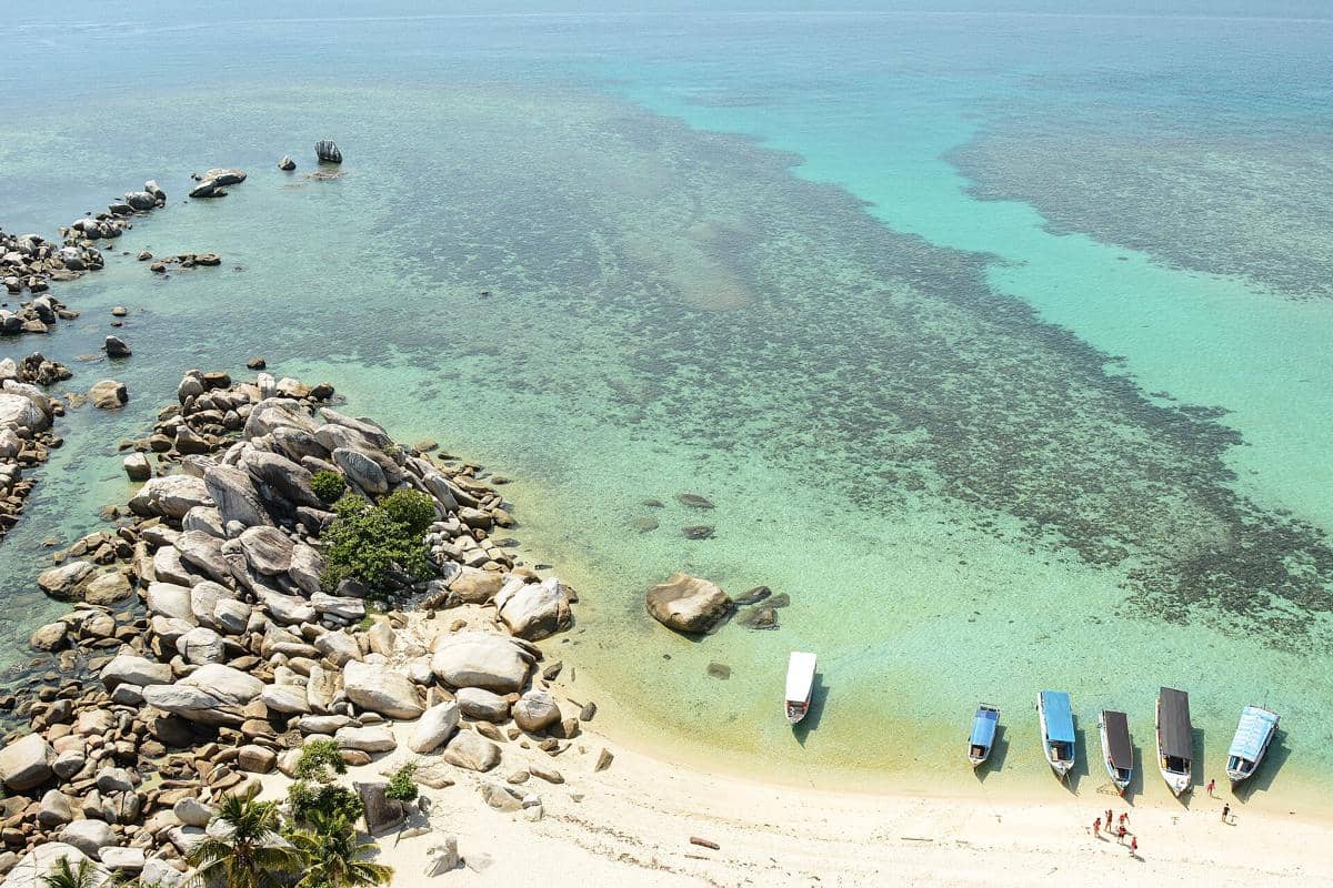 Ilustrasi Pulau Belitung dengan lanskap pesisir dan perairan biru, dikreditkan kepada Teodorus Alfons.