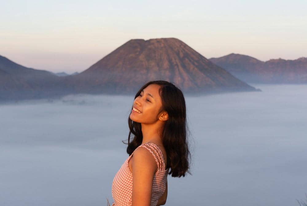 ilustrasi seorang perempuan berfoto dengan latar belakang Gunung Bromo