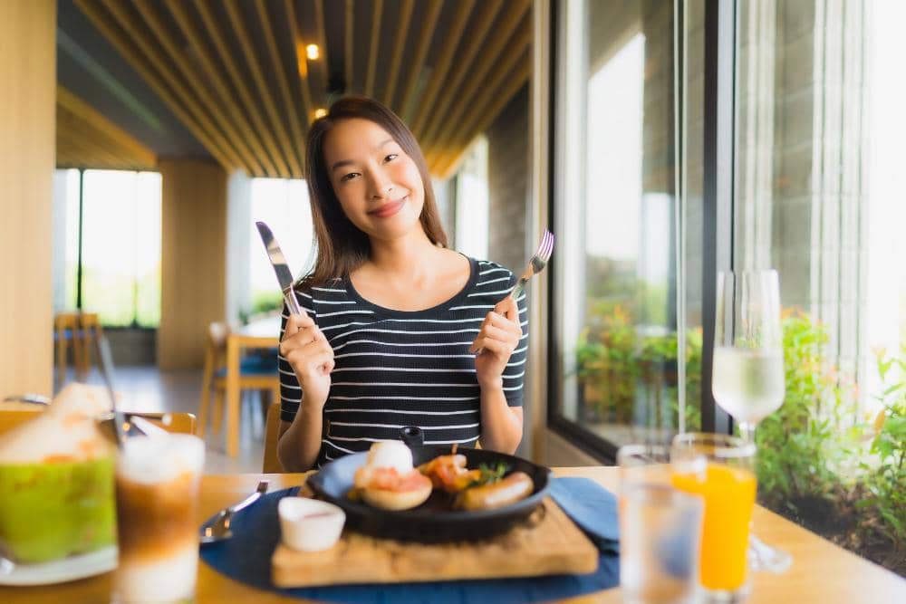 Ilustrasi seorang perempuan sedang makan, menggambarkan aktivitas menikmati hidangan dalam kehidupan sehari-hari.