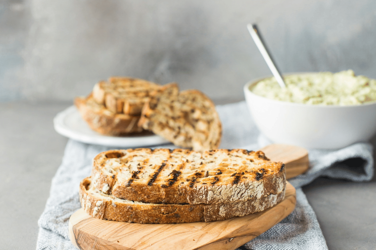 Ilustrasi proses membuat sandwich dengan bahan makanan di atas meja, karya Anna Tukhfatullina Food Photographer/Stylist.