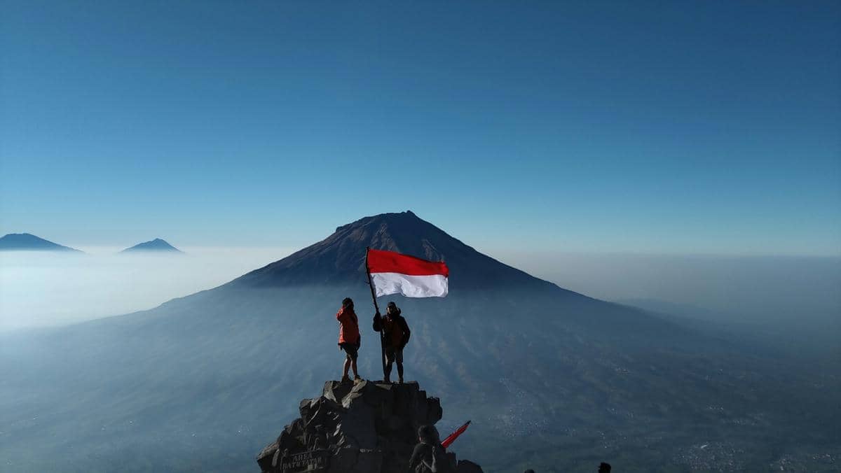 ilustrasi mengibarkan bendera Merah Putih di puncak gunung