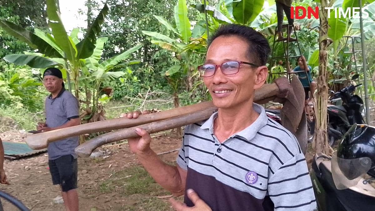 Seorang warga bersiap membantu penggalian makam Sutrimo pada Rabu, 12 Agustus 2026 di area pemakaman setempat.