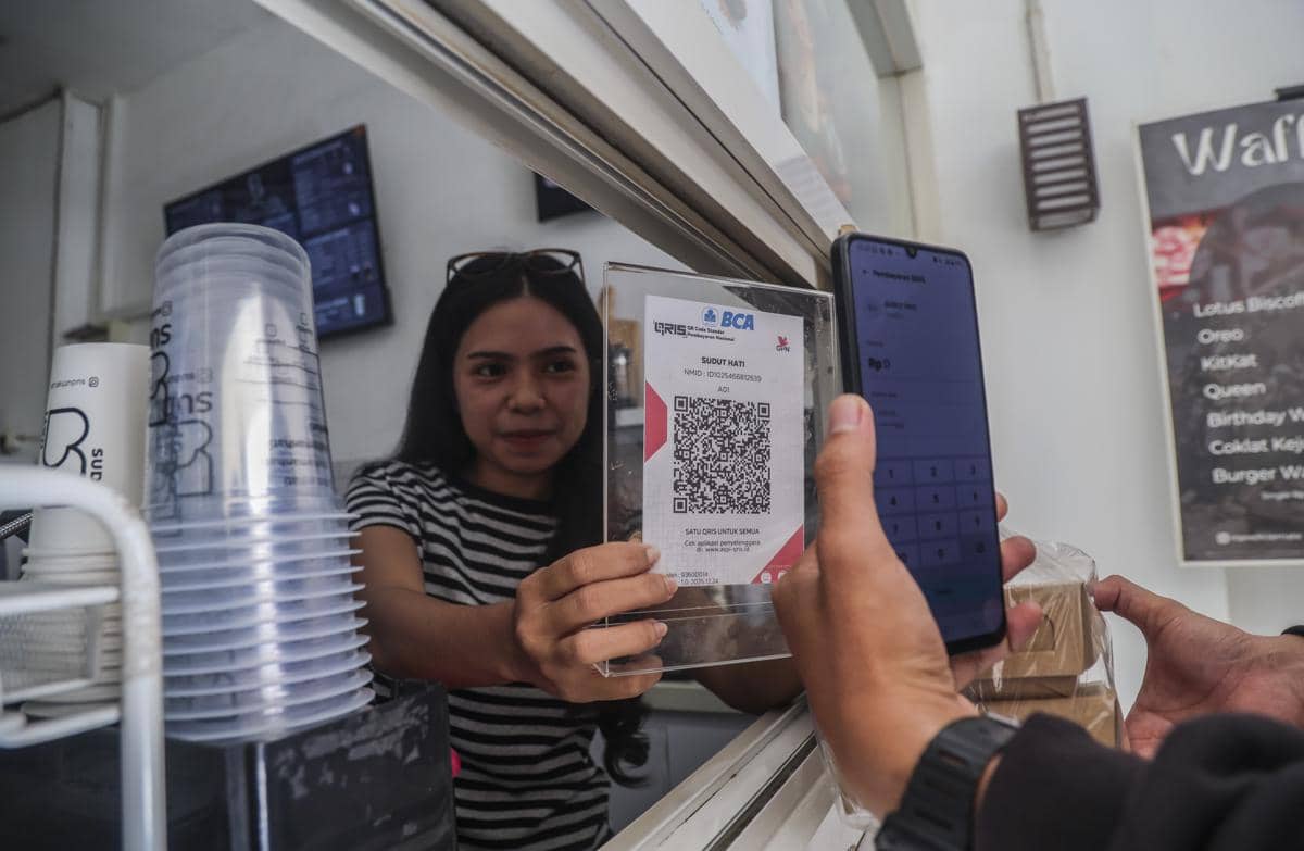 Penjual melayani pembeli yang membayar menggunakan QRIS. ( ANTARA FOTO/Andri Saputra)ransaksi-pada-semester-i-2026-1786616333.jpg