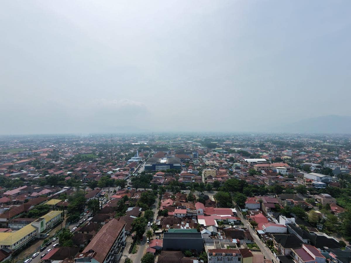 Kota Padang diselimuti kabut asap yang membuat pemandangan wilayah perkotaan dan langit tampak kelabu serta samar.