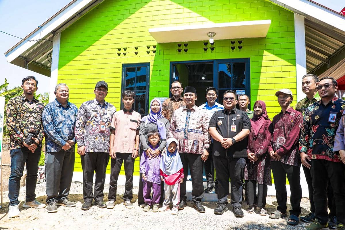 Isnano, istri, dan anaknya berpose bersama Wakil Gubernur Jawa Tengah Taj Yasin Maimoen di depan rumah bata interlock.