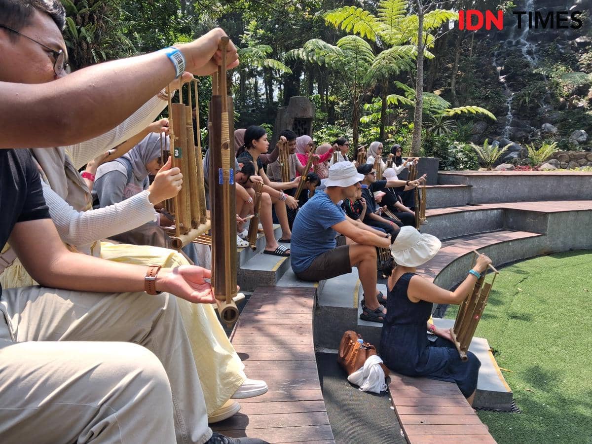 Pengunjung Enchanting Valley memainkan angklung bersama dalam pertunjukan interaktif pada Jumat, 15 Agustus 2026.