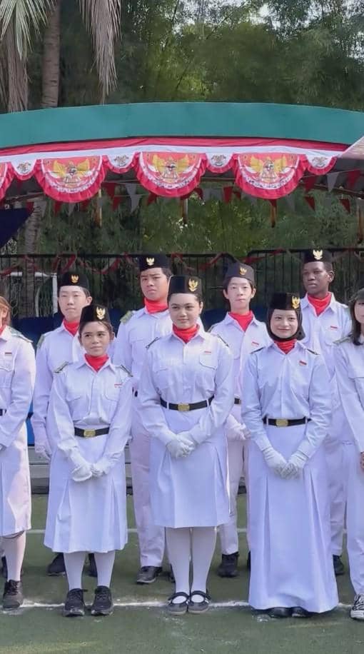 Amora Lemos mengenakan seragam paskibra putih lengkap dengan topi saat mengikuti upacara 17 Agustus resmi.