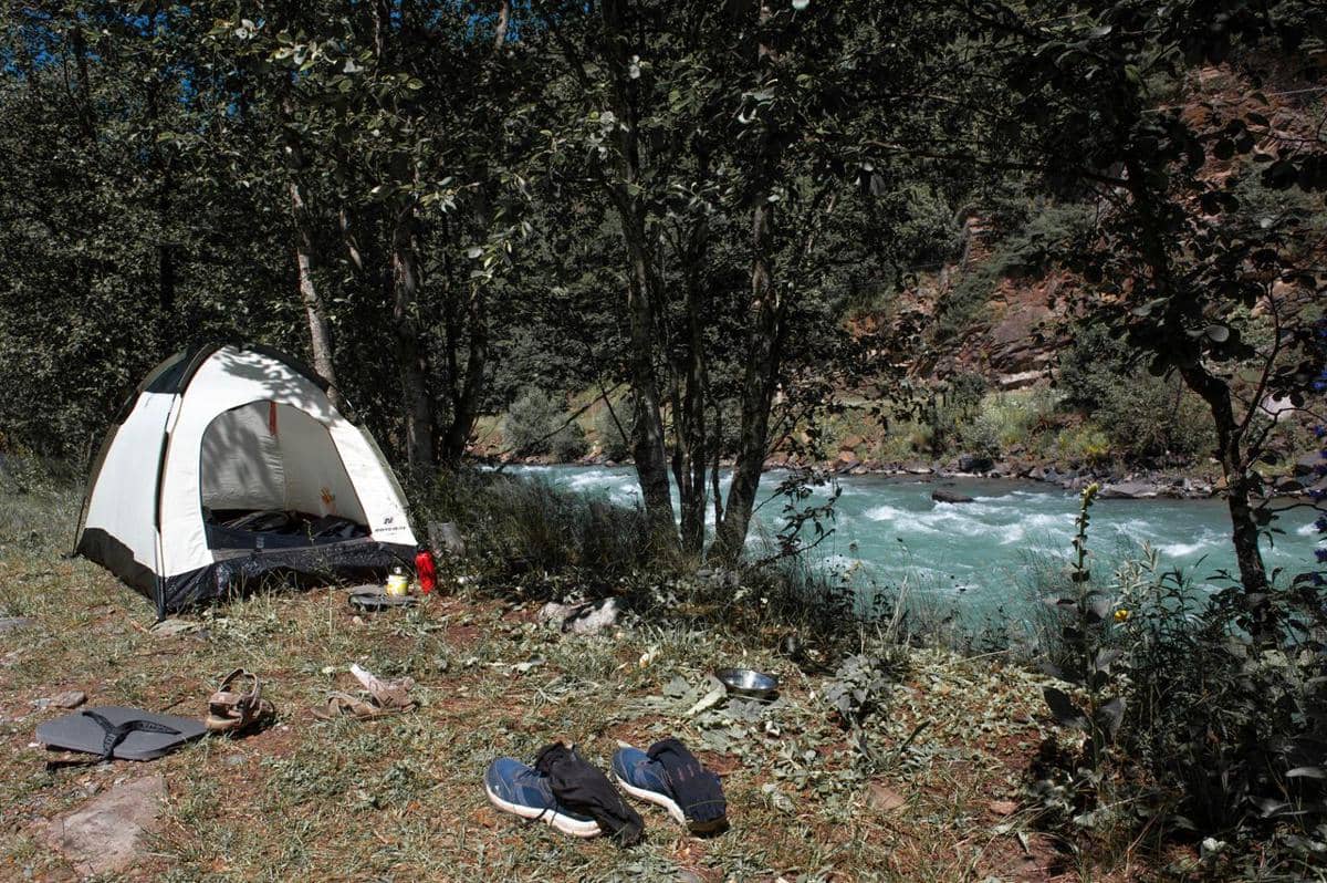 ilustrasi camping dekat sungai