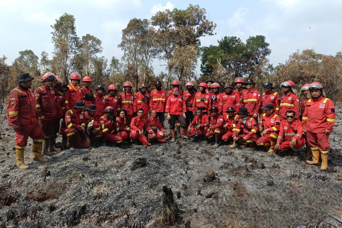 Tim Manggala Agni saat menggelar upacara bendera di tengah lahan terbakar di Desa Sungai Rambutan, Kabupaten Ogan Ilir, Sumatra Selatan, Senin (17/8/2026). 