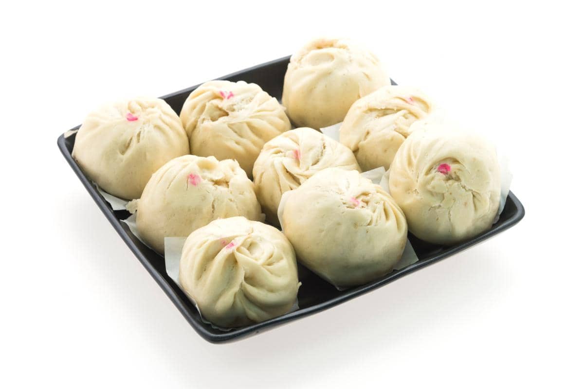 Ilustrasi dumpling berwarna cerah dengan bentuk lipatan khas, disajikan sebagai visual makanan Asia.