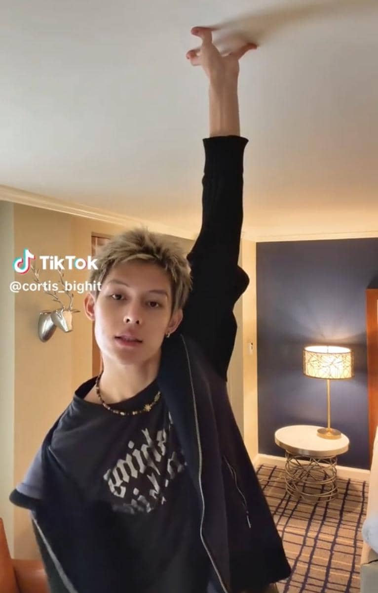 Potret James, anggota CORTIS, dalam unggahan TikTok dengan tampilan kasual dan ekspresi serius ke arah kamera.