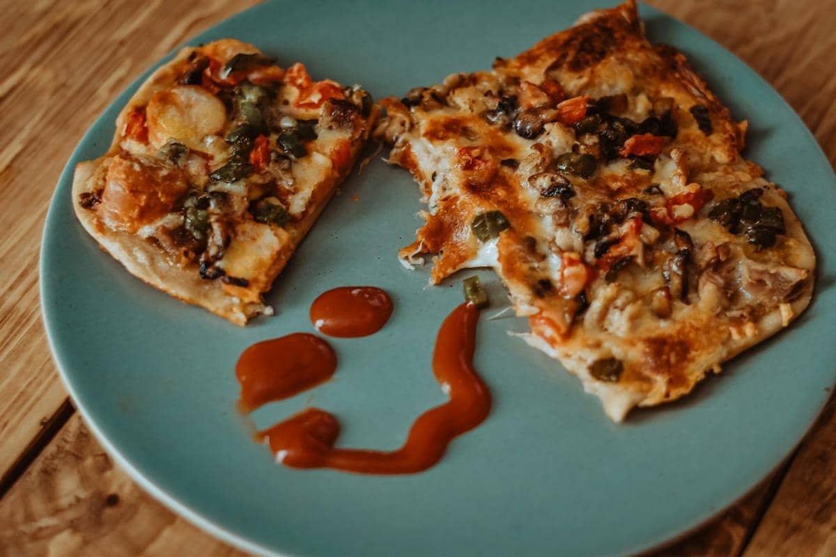 Ilustrasi flatbread dengan potongan ayam panggang dan sayuran segar, disajikan di atas alas putih sederhana.