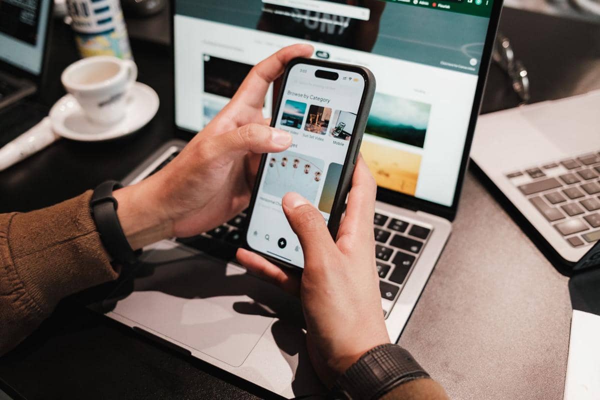 Seseorang menggunakan smartphone sebagai ilustrasi aktivitas digital sehari-hari melalui perangkat seluler.