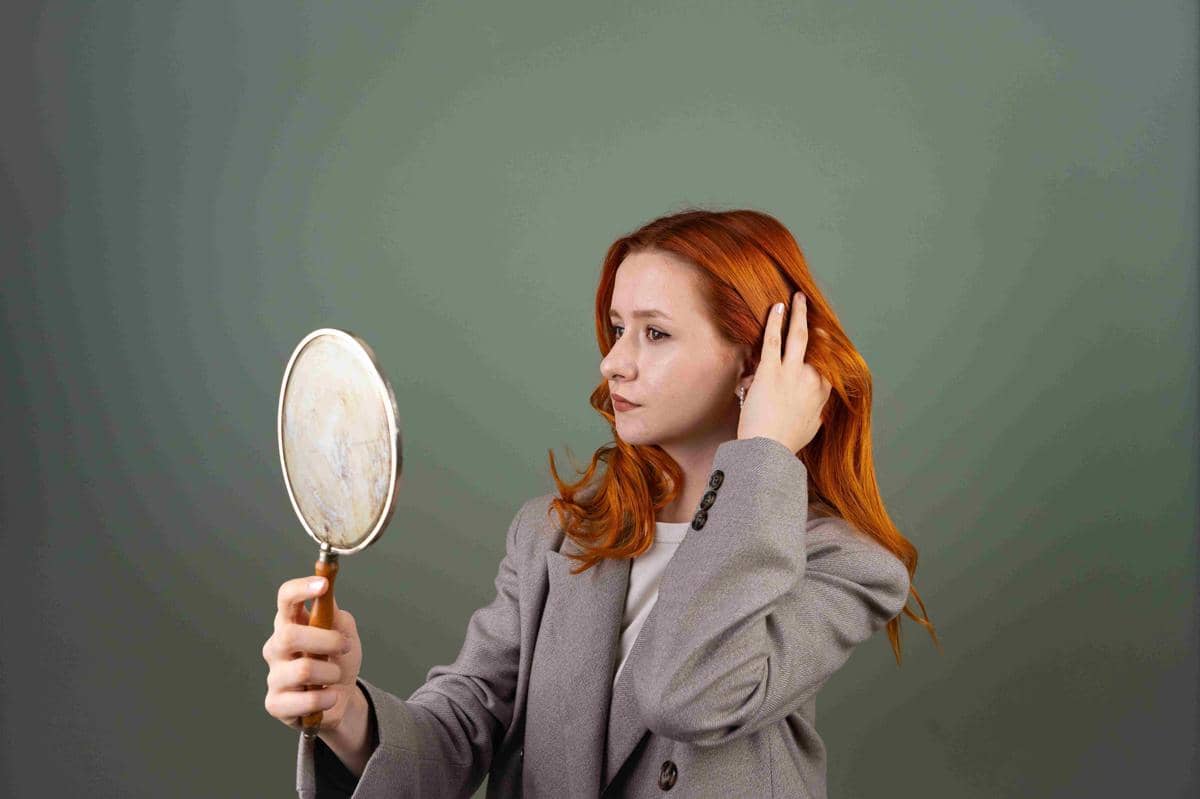 Ilustrasi perempuan berambut panjang mengubah belahan rambut untuk tampilan gaya rambut yang berbeda.