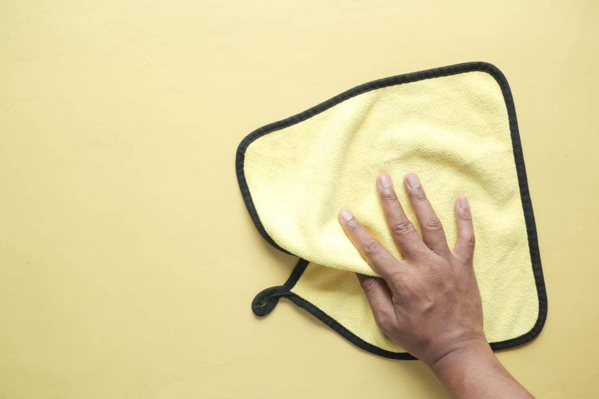 Ilustrasi tangan memegang kain lap kuning