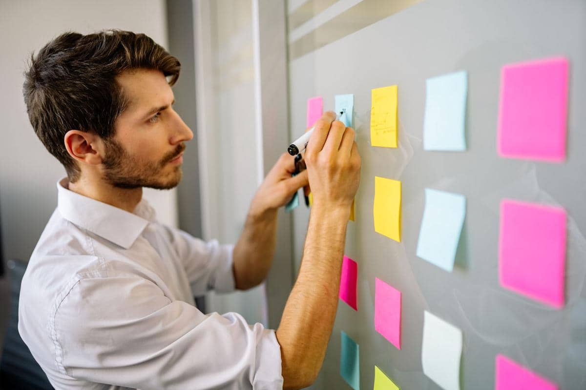 ilustrasi pria menulis di sticky note