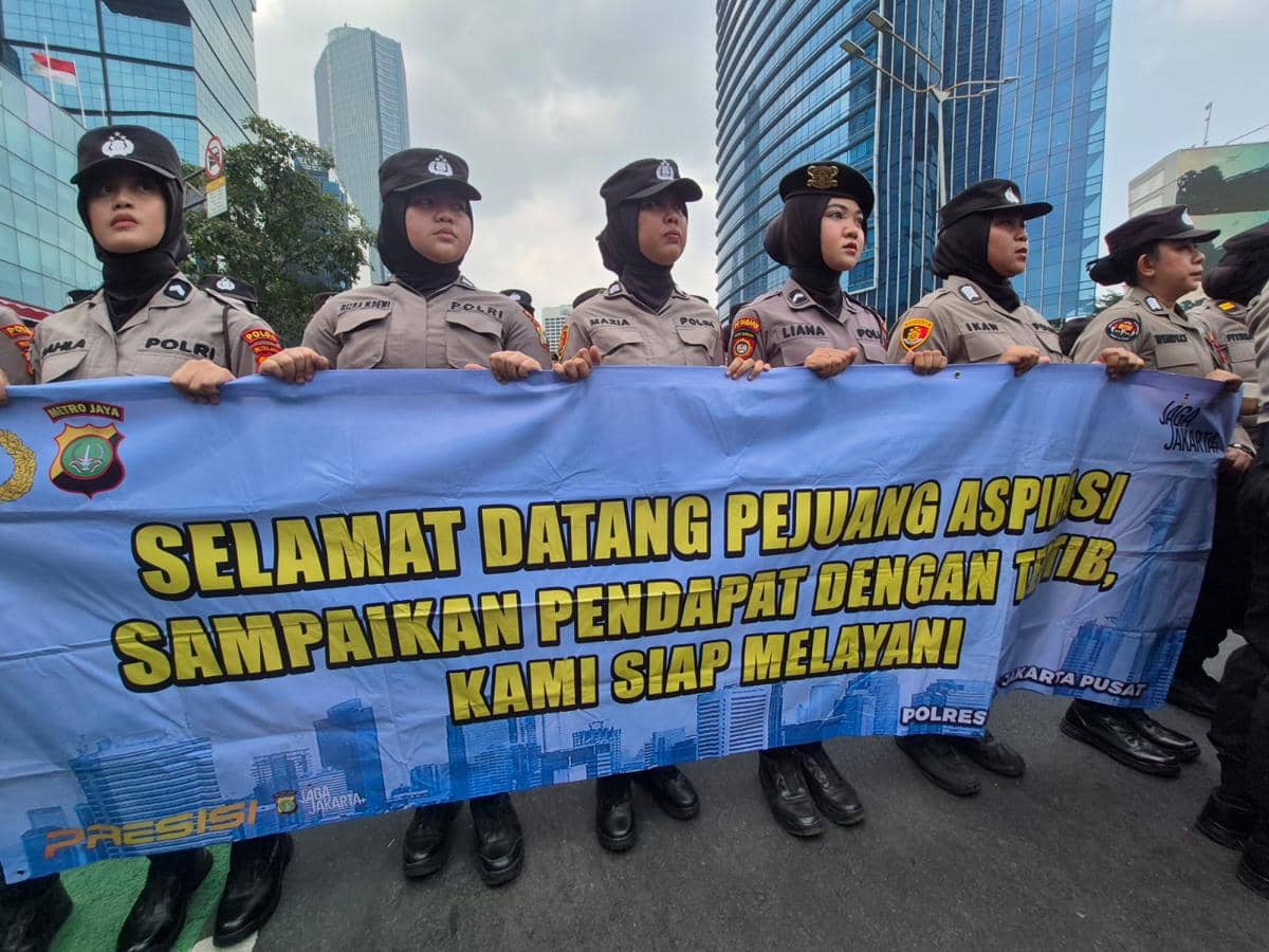 Polwan yang membentangkan spanduk dengan tulisan 'selamat datang pejuang aspirasi'.