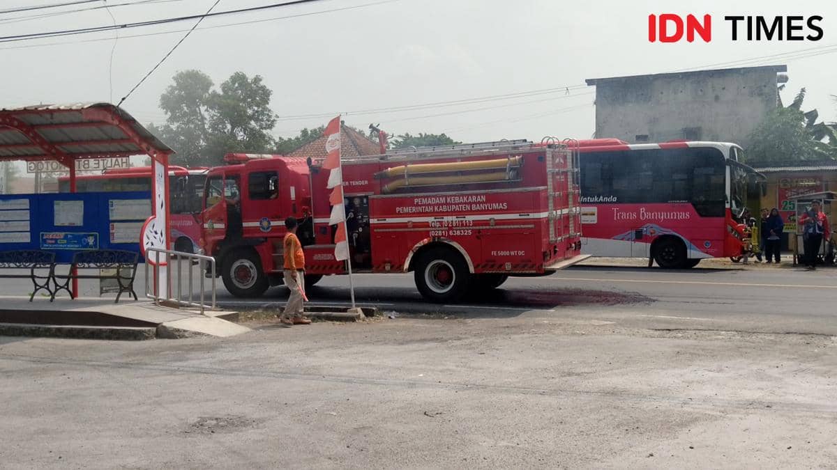 Bus Trans Banyumas diamankan keluar dari area terminal saat mobil pemadam kebakaran menangani insiden kebakaran.