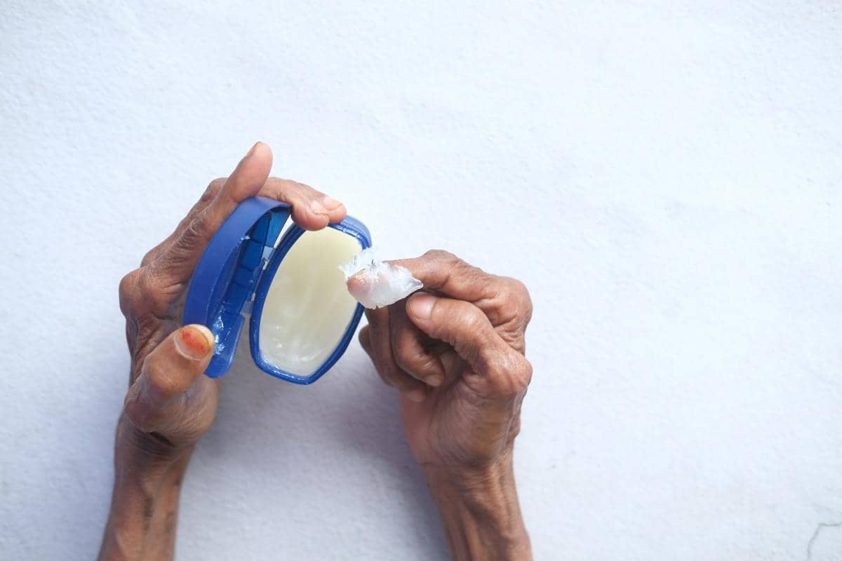 Ilustrasi petroleum jelly dalam wadah terbuka untuk perawatan kulit dan membantu menjaga kelembapan area kering.