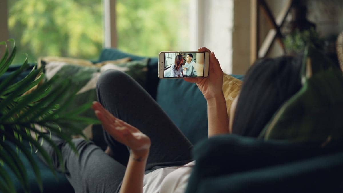 Seorang wanita melakukan panggilan video di sofa