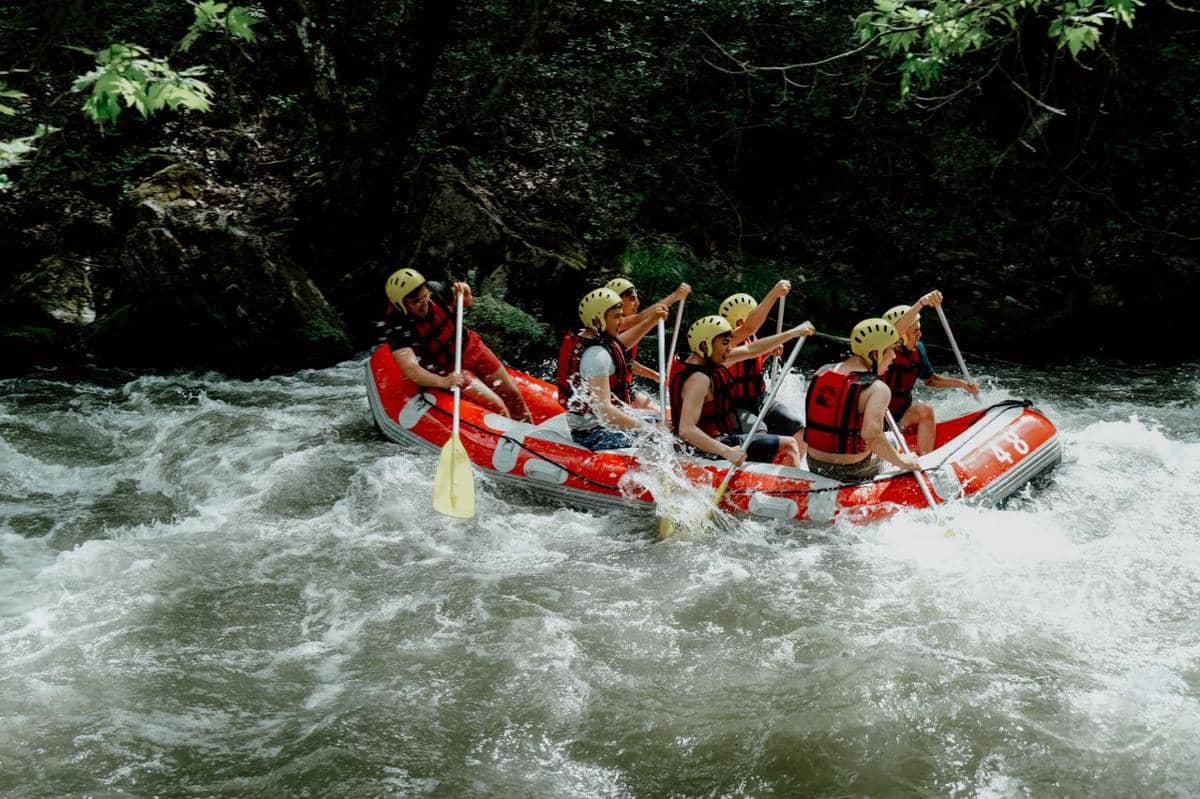 ilustrasi sekelompok orang menikmati arung jeram