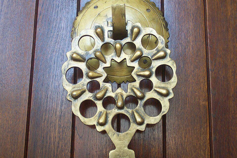 Detail gagang pintu berbahan kuningan pada Masjid Raja Saud, menonjolkan ornamen logam berwarna emas di area pintu.