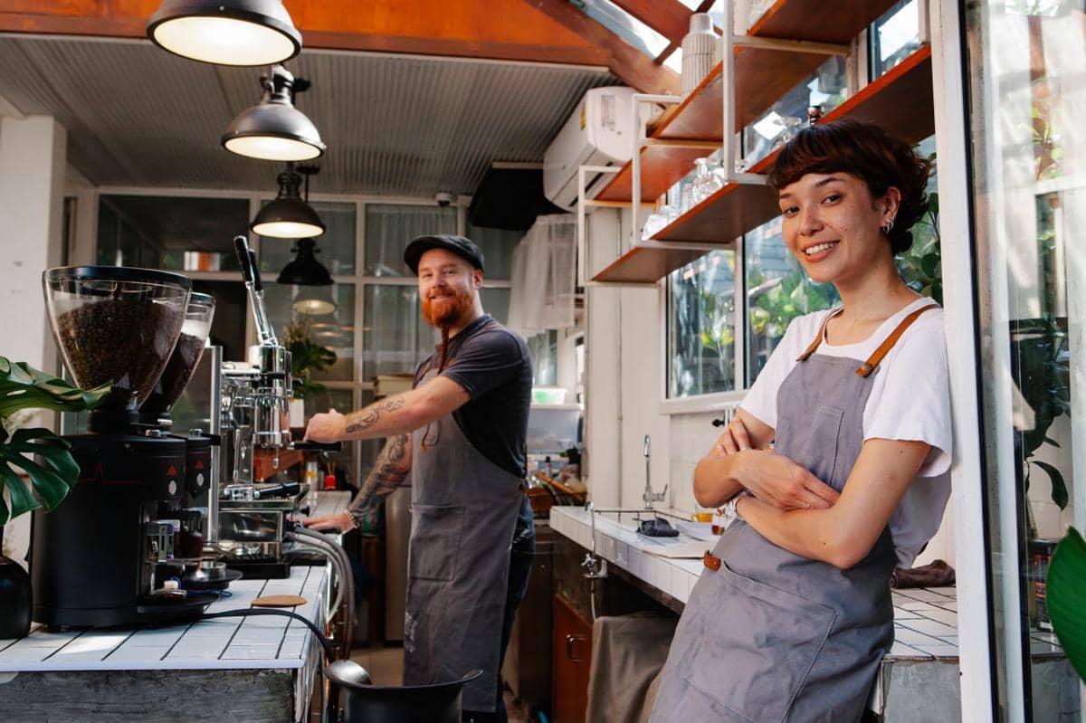 ilustrasi dua barista yang tersenyum bekerja di kedai kopi modern