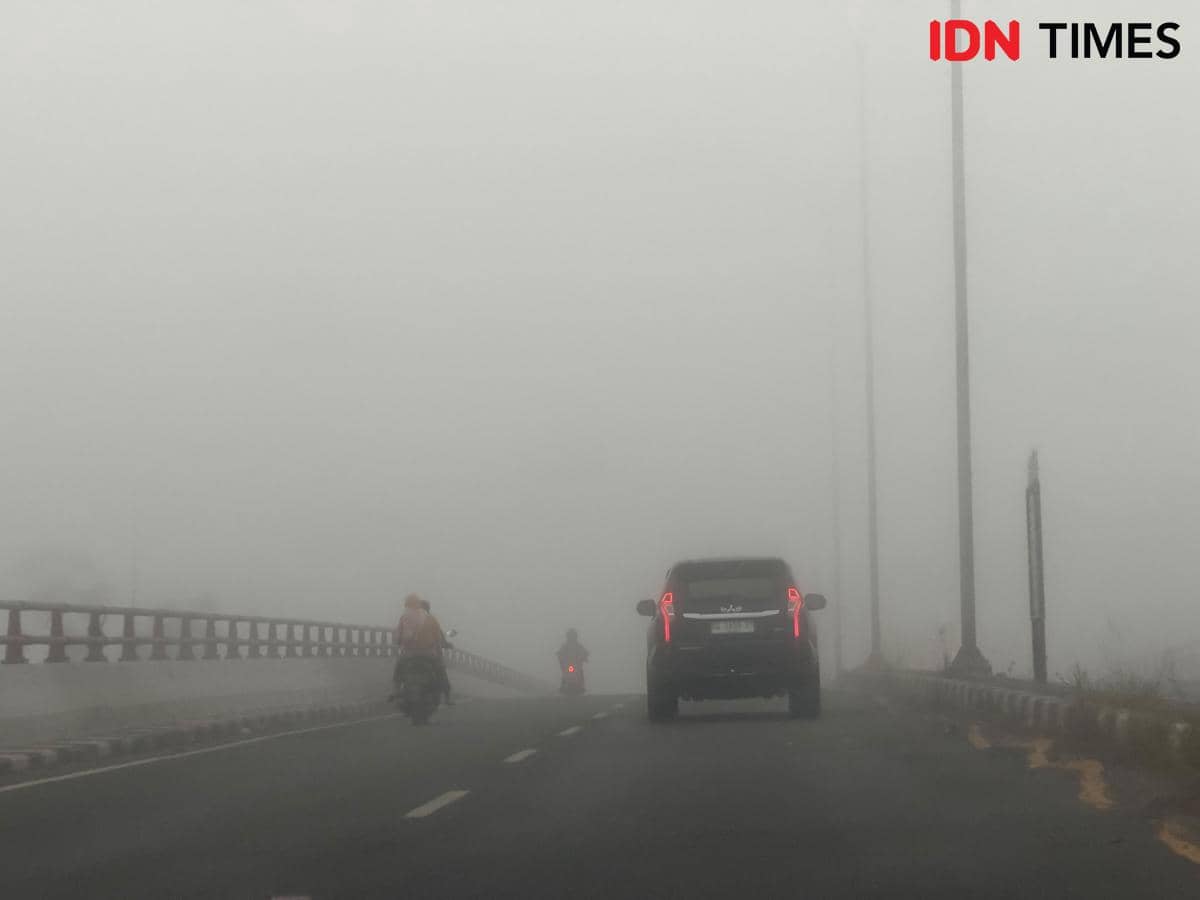 Kabut asap menyelimuti kawasan Keramasan di Palembang, mengaburkan akses jalan menuju Tol Palembang-Indralaya.