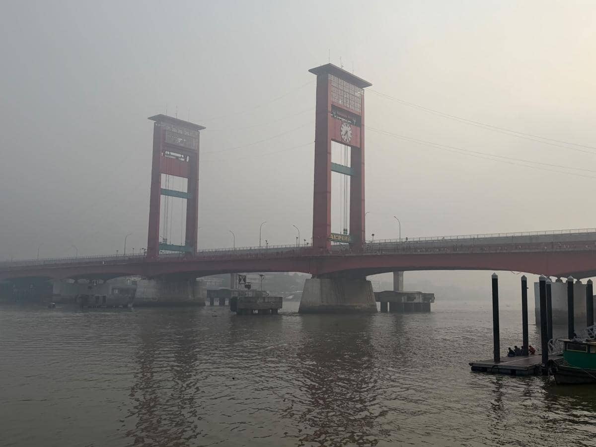 Kabut asap tebal menyelimuti Palembang, dengan Jembatan Ampera tampak samar di kejauhan pada Minggu, 23 Agustus 2026.