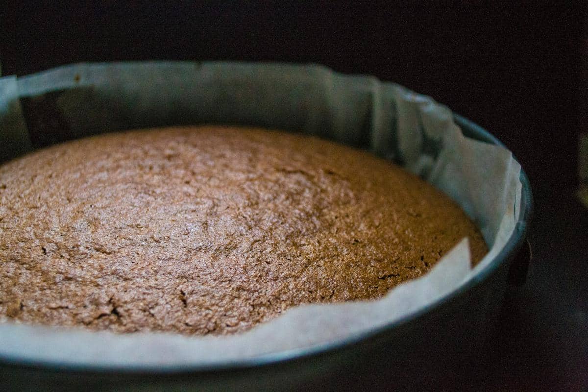 Ilustrasi proses membuat kue cokelat Guinness dengan adonan, peralatan memanggang, dan bahan kue di dapur.
